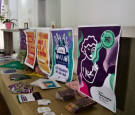 Mesa com diversos materiais sobre aborto e justiça reprodutiva.