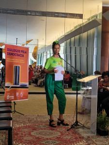 Mulher vestida de verde em frente a um púlpito.