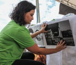 Foto: Chama. Mulher cola cartaz pela legalização do aborto.