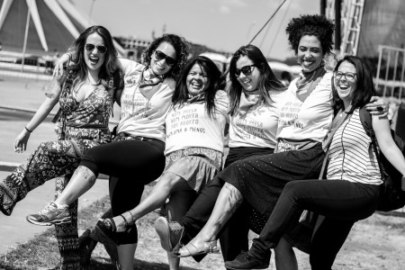 Foto: Chama. Seis mulheres entre elas parlamentares e militantes, se abraçam e levantam as pernas sorrindo.