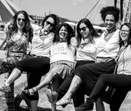 Foto: Chama. Seis mulheres entre elas parlamentares e militantes, se abraçam e levantam as pernas sorrindo.