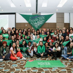 Foto de Alexa Rochi. Representantes das organizações latinas e caribenhas posam em frente a um lenço verde grande.