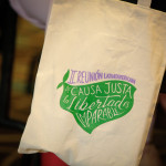 Foto de Alexa Rochi. Foto de uma Ecobag, onde se lê, em lilás e roxo: "II Reunión latinoamericana de Causa Justa la Libertad es imparable"