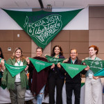 Foto de Monica Cotes - Trineo Comunicaciones. Sete pessoas, sendo 6 mulheres e um homem, seguram lenços verdes e posam em frente a um grande lenço onde se lê "De Causa Justa la Libertad es imparable", em espanhol.