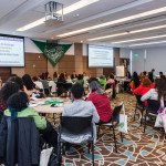 Foto de Monica Cotes - Trineo Comunicaciones. Participantes estão divididas em mesas circulares na sala de reunião.