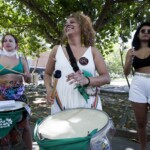 Batucada Unificada feminista no ensaio para a apresentação do Dia 28 de Setembro. Foto: Kati Tortorelli. Três mulheres tocam instrumentos de batucada com lenços verdes.