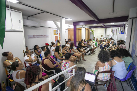 A Roda de Conversa na Casa das Mulheres da Maré reuniu cerca de 35 participantes. Foto: Gabi Lino Mulheres estão sentadas em cadeiras em uma sala com cartazes nas paredes.
