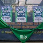 O “Carro do Óvulo” é uma criação de parcerias de Porto Alegre, trazida para o WOW: O carro dispõe de sistema de som e veicula mensagens sobre justiça reprodutiva, ao mesmo tempo que se distribui materiais informativos pelos bairros populares. Foto: Amara Barroso. Parte traseira de um carro de som, onde estão dispostos lenços verdes e alguns cartazes da ação "Carro do óvulo".