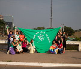 Mulheres seguram lenço verde gigante, onde diz: Nem Presa Nem Morta.