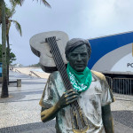 A estátua de Tom Jobim, no Arpoador, recebeu um adereço da luta pela legalização do aborto no amanhecer do dia 28 de Setembro. Foto: Amanda Gabriel. Foto da estátua de Tom Jobim vestindo lenço verde, no Arpoador.