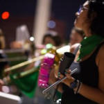 A Batucada Feminista embalou canções e palavras e ordem pela legalização do aborto no ato. Foto: Andressa Anholete. Mulheres tocando instrumentos na batucada. Elas vestem lenços verdes da campanha Nem Presa Nem Morta.