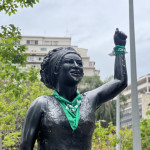 A estátua de Marielle Franco, no Buraco do Lume/ Centro, recebeu um adereço da luta pela legalização do aborto no amanhecer do dia 28 de Setembro. Foto: Marina Laiun. Foto da estátua de Marielle Franco vestindo lenço verde no Buraco do Lume/ Centro do Rio de Janeiro.