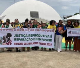 Bibiane Serpa / Acervo Nem Presa Nem Morta Foto com mulheres com a faixa: Justiça Reprodutiva é reparação e Bem Viver - Marcha das Mulheres Negras 2025. Atrás, o prédio do Museu Nacional da República, em Brasília.