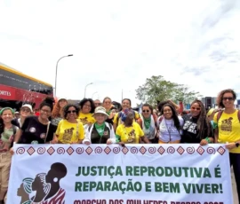 Foto com diversas mulheres carregando uma faixa, com o texto: Justiça Reprodutiva é reparação e Bem Viver - Marcha das Mulheres Negras 2025.