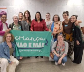 Foto da comitiva de mulheres com a bandeira da campanha Criança Não é Mãe. Ao centro, a deputada federal Juliana Cardoso PT/SP.