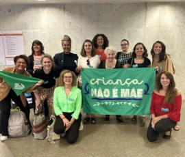 Foto da comitiva de mulheres da campanha Criança Não é Mãe, com lenços e a bandeira.